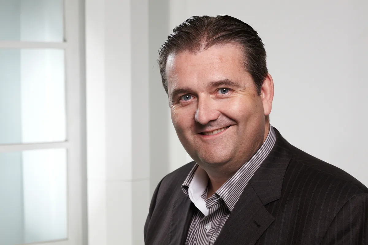 Porträtfoto eines lächelnden Mannes.